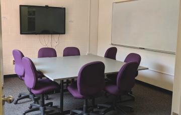 Room 309 with table, chairs, display screen, and whiteboard